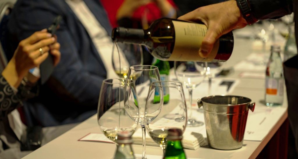Bulgarian Wine Recognition – Professional Tastings and Wine Competitions Bulgarian wine recognition at professional tastings, with wine being poured for judges during an international competition